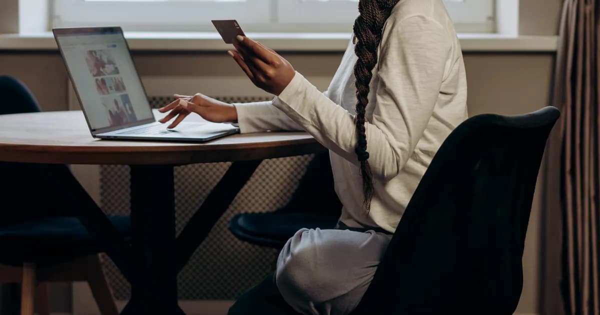Mulher conclui compra online com notebook e cartão.
