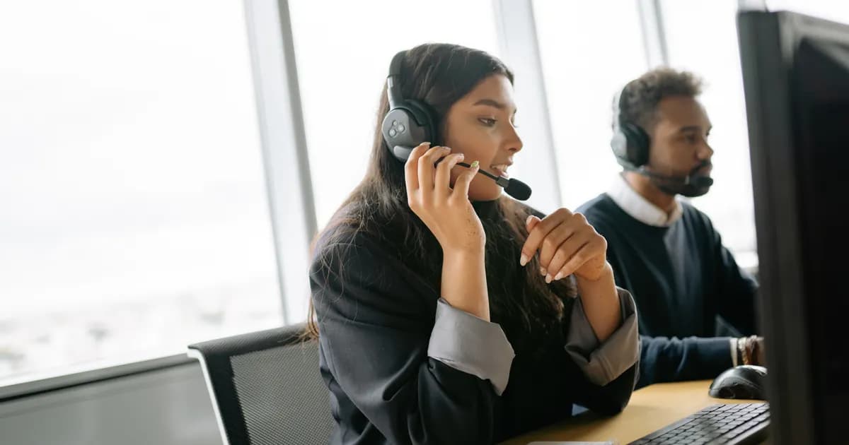 Equipe de atendimento trabalha em computadores com headset.