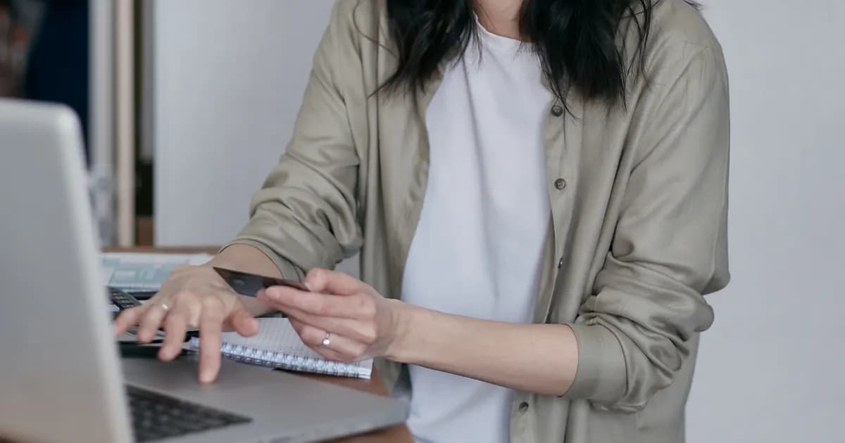 Mulher organiza contas e pagamentos em notebook.