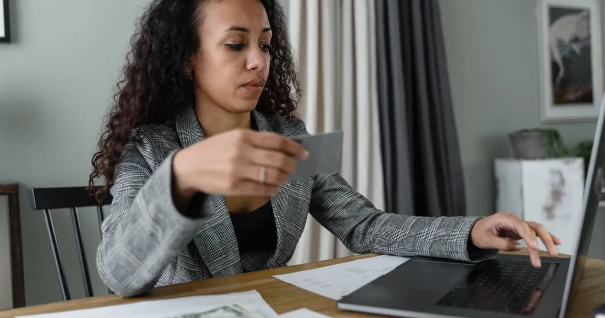 Profissional analisa finanças com notebook e dinheiro.