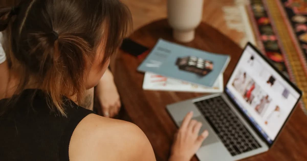 Duas pessoas pesquisam produtos em um notebook.