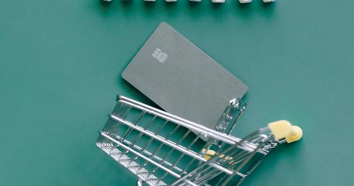 Miniatura de carrinho de compras ao lado de cartão.